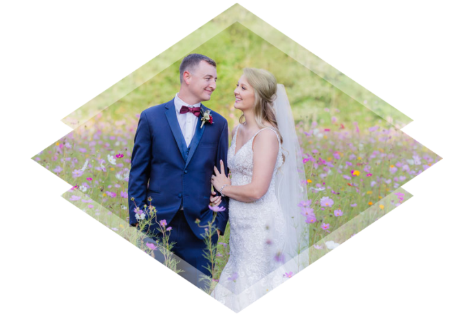 A bride and groom stands in a field of flowers